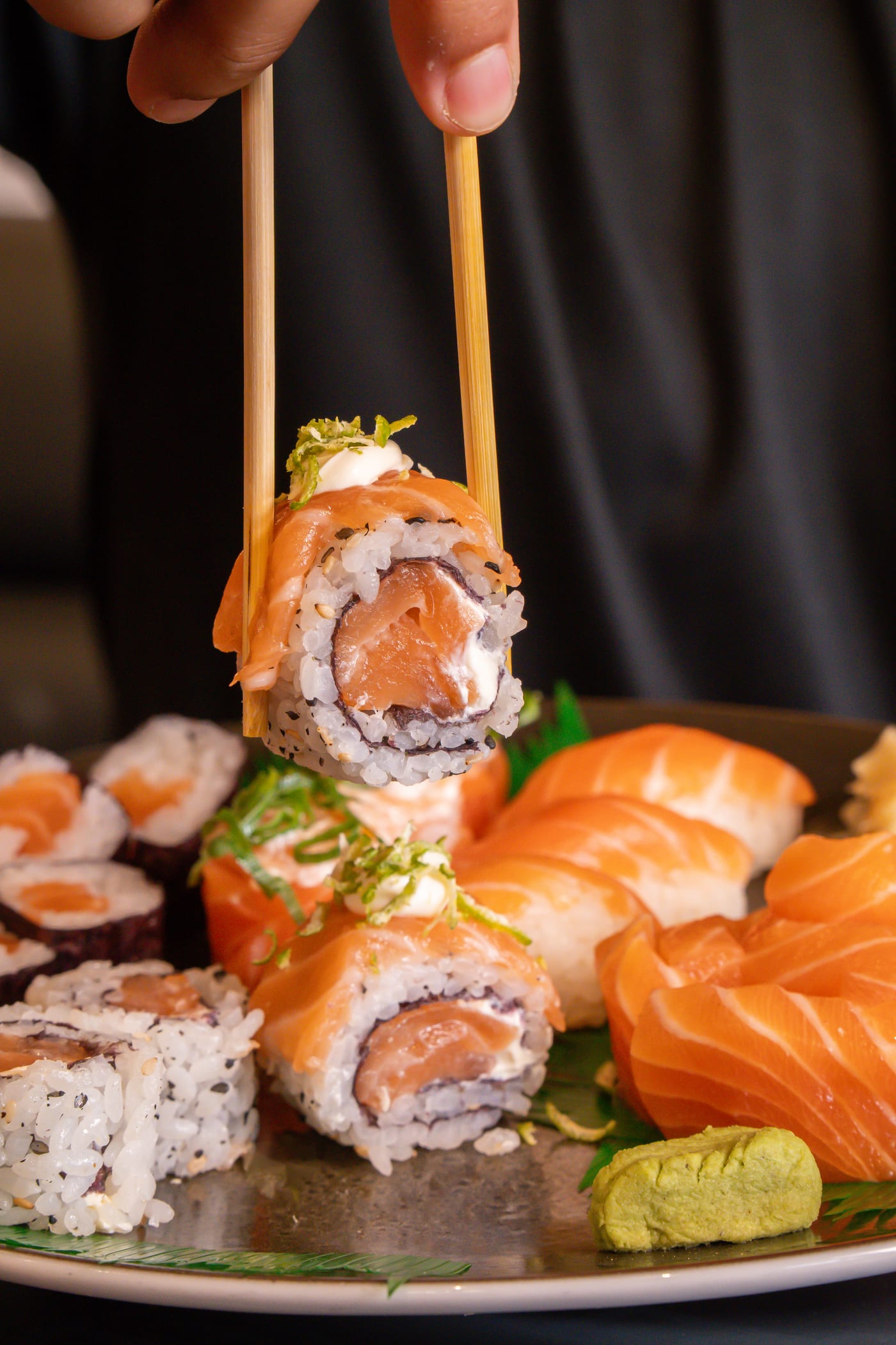 Sushi de salmão sendo servido com hashi · Temakeria Universitária