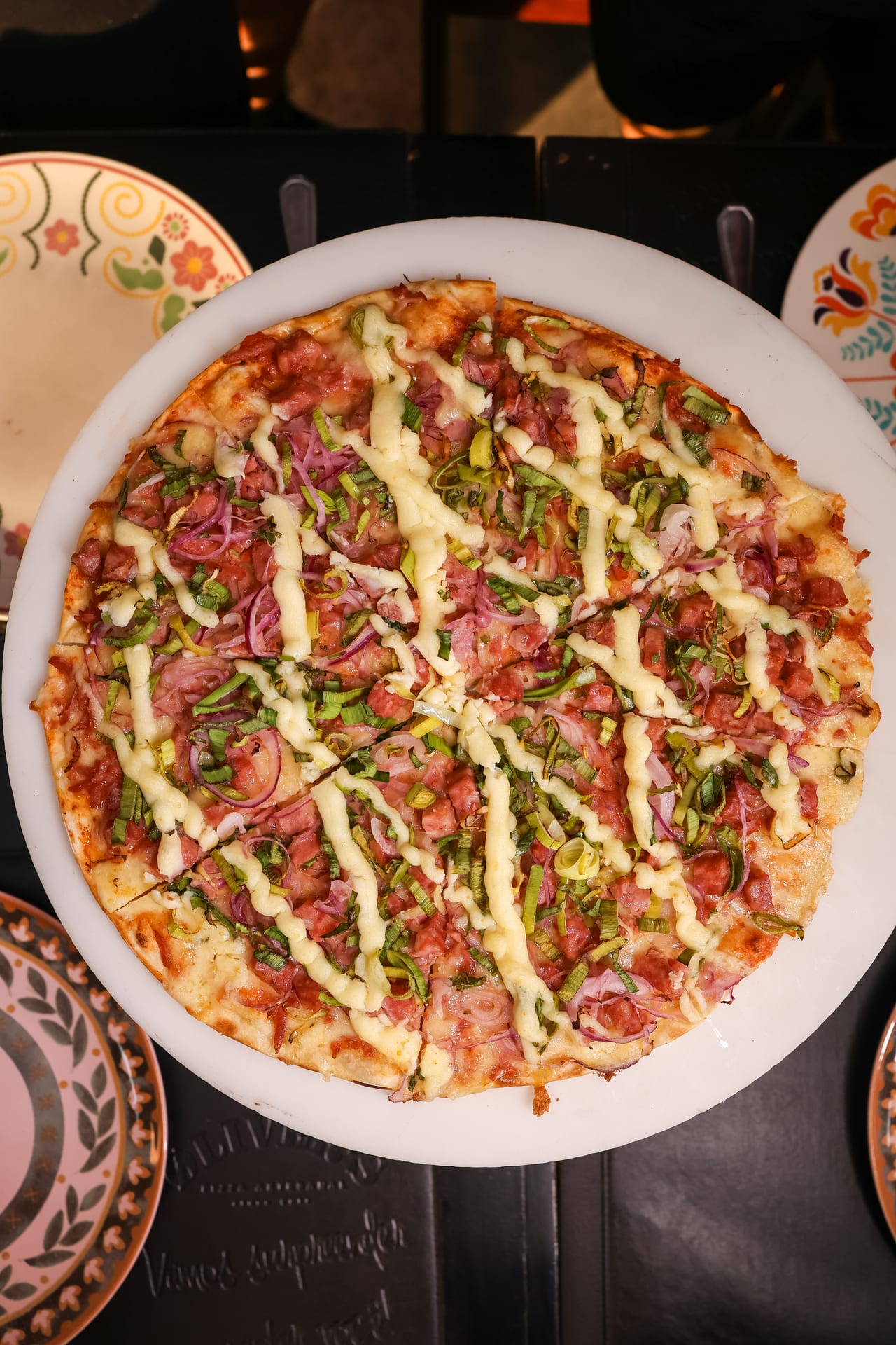 Pizza Øliver's sendo servida em prato artesanal · vista de cima